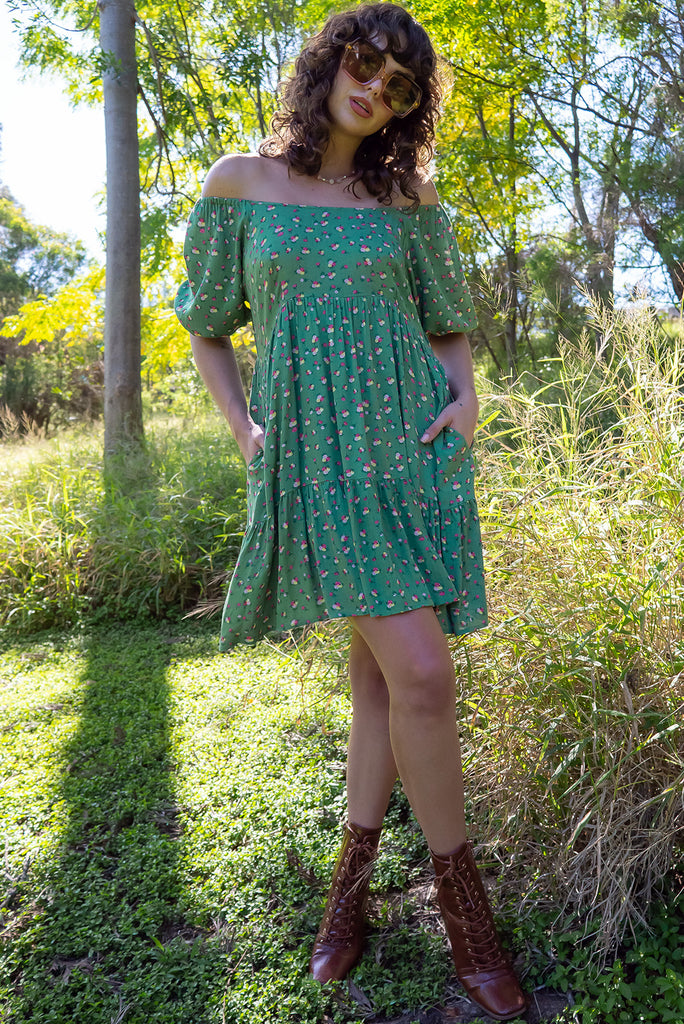 The Emelia Green Flowers Short Dress is a gorgeous green mini dress with a small white and pink floral print. The mini dress features 3/4 sleeves with elastic cuffs, tiered skirting and side pockets. Made from a woven blend of crinkle rayon.