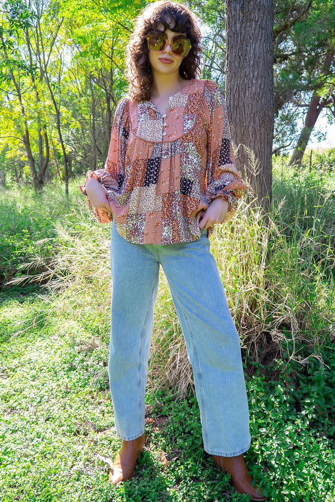 The Emmylu Caramel Patch Boho Blouse is a beautiful caramel toned patchwork print blouse. The blouse features a yoke neckline with functional buttons, long flowy sleeves with elasticated cuffs, and a slightly longer back. Made from woven 100% rayon. 