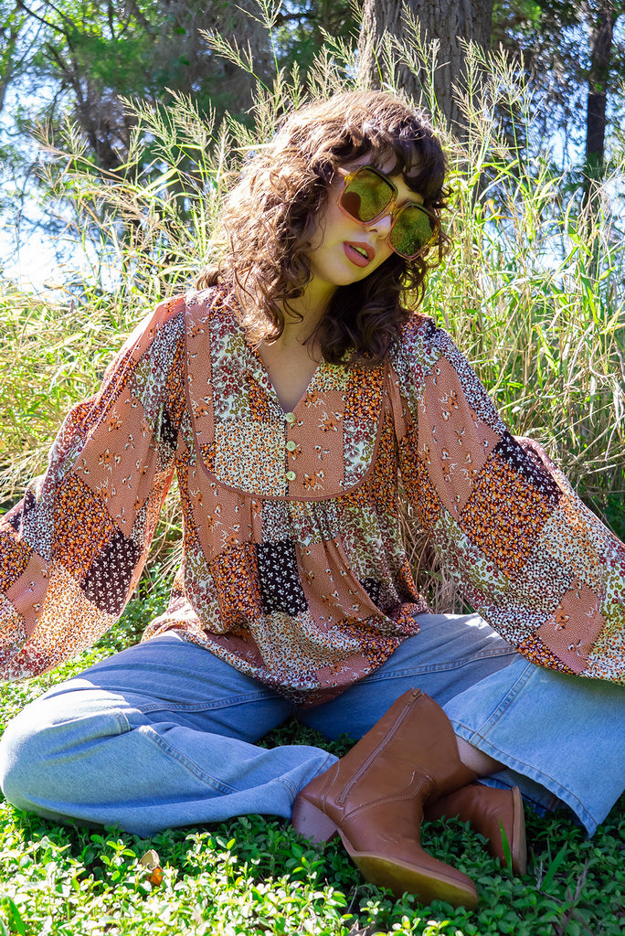 The Emmylu Caramel Patch Boho Blouse is a beautiful caramel toned patchwork print blouse. The blouse features a yoke neckline with functional buttons, long flowy sleeves with elasticated cuffs, and a slightly longer back. Made from woven 100% rayon. 