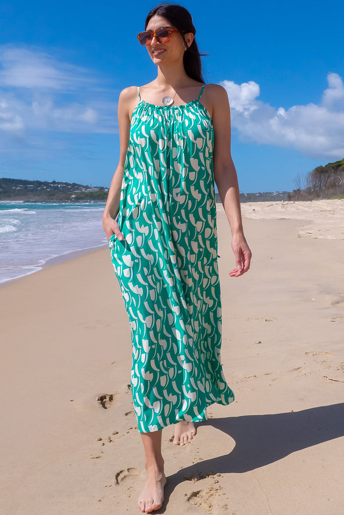 The Erakor Jungle Geo Maxi Dress is a gorgeous green maxi dress with a White Island inspired print. The dress features an oversized slip on style, adjustable halter neckline, and side pockets. This dress is reversible. Made from woven rayon.