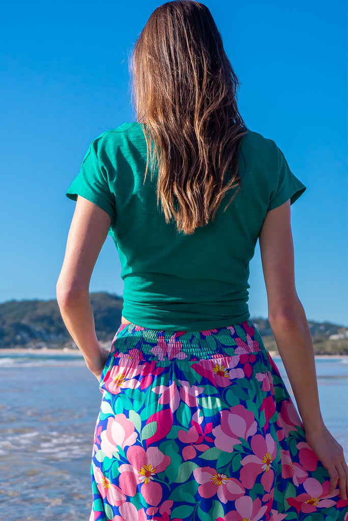 The Flirt Flora Button Front Maxi Skirt is a beautiful blue based skirt with a bright, pink and green floral print. The skirt features a waist yoke with blue piping, functional buttons from waist to hem, elasticated back of waist, and side pockets. Made from 100% rayon. 