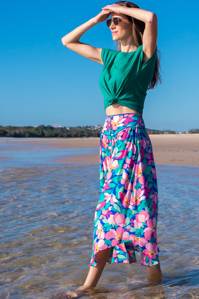 The Flirt Flora Button Front Maxi Skirt is a beautiful blue based skirt with a bright, pink and green floral print. The skirt features a waist yoke with blue piping, functional buttons from waist to hem, elasticated back of waist, and side pockets. Made from 100% rayon. 