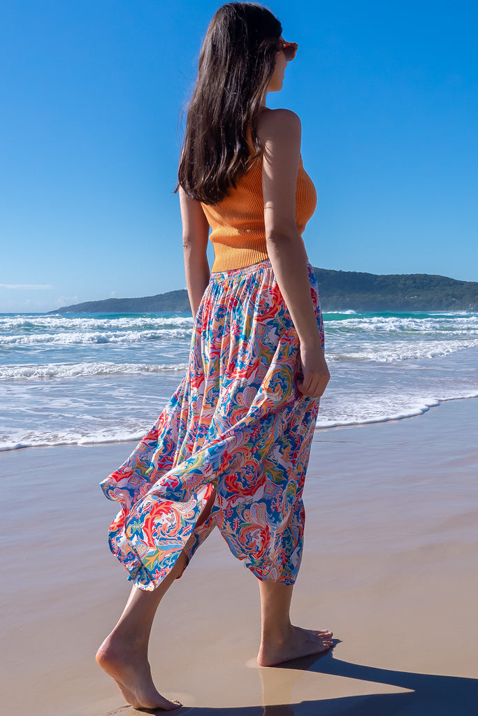 The Flirt Spice Button Front Maxi Skirt is a beautiful blue based skirt with a bright, multicoloured paisley design. The skirt features a waist yoke with white piping, functional buttons from waist to hem, elasticated back of waist, and side pockets. Made from 100% rayon. 