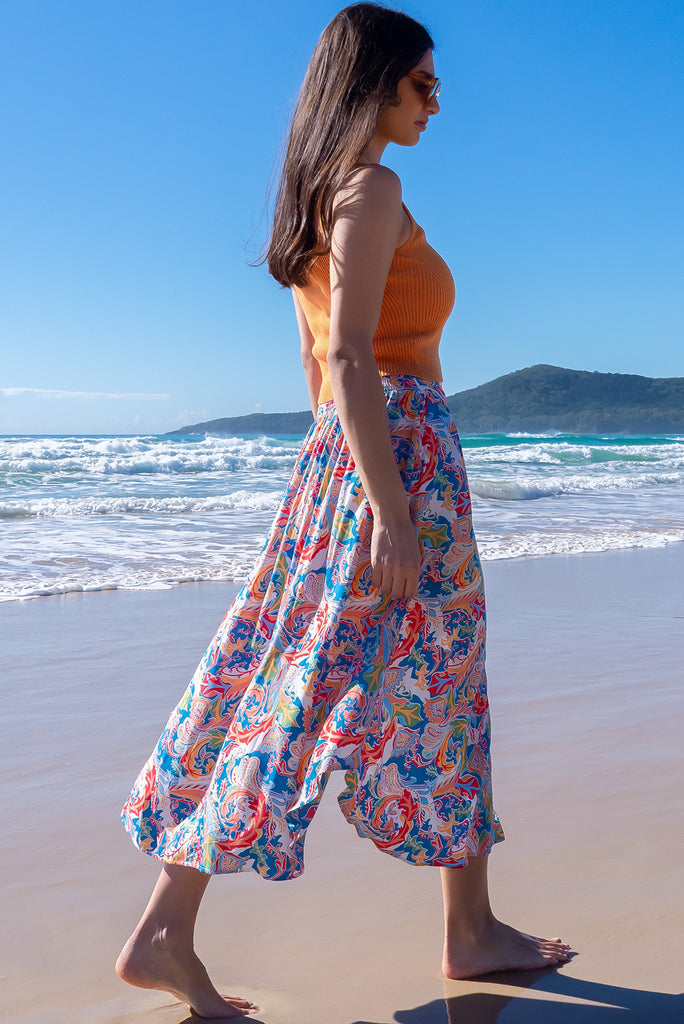 The Flirt Spice Button Front Maxi Skirt is a beautiful blue based skirt with a bright, multicoloured paisley design. The skirt features a waist yoke with white piping, functional buttons from waist to hem, elasticated back of waist, and side pockets. Made from 100% rayon. 