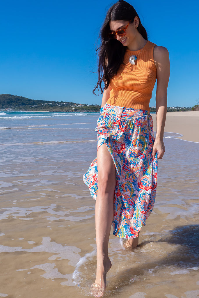 The Flirt Spice Button Front Maxi Skirt is a beautiful blue based skirt with a bright, multicoloured paisley design. The skirt features a waist yoke with white piping, functional buttons from waist to hem, elasticated back of waist, and side pockets. Made from 100% rayon. 