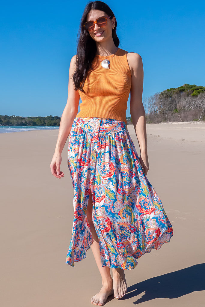 The Flirt Spice Button Front Maxi Skirt is a beautiful blue based skirt with a bright, multicoloured paisley design. The skirt features a waist yoke with white piping, functional buttons from waist to hem, elasticated back of waist, and side pockets. Made from 100% rayon. 