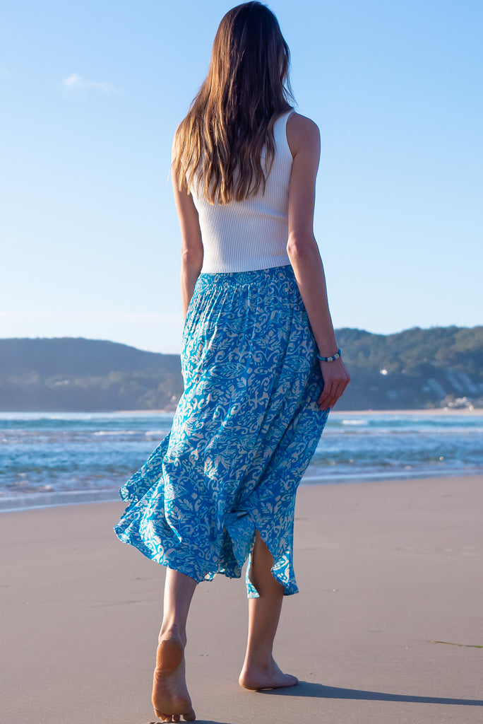 The Flirt Teal Maxi Skirt is a beautiful blue based skirt with a cream paisley design. The skirt features a waist yoke with white piping, functional buttons from waist to hem, elasticated back of waist, and side pockets. Made from 100% rayon. 