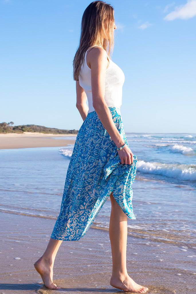 The Flirt Teal Maxi Skirt is a beautiful blue based skirt with a cream paisley design. The skirt features a waist yoke with white piping, functional buttons from waist to hem, elasticated back of waist, and side pockets. Made from 100% rayon. 