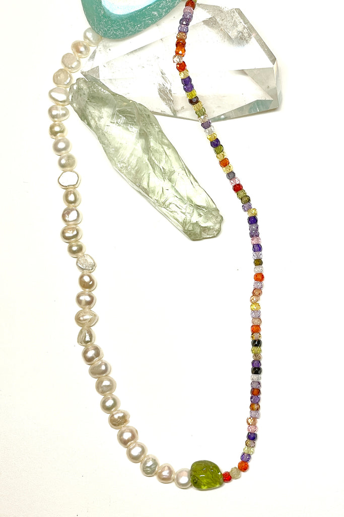 A chic and cool summer necklace made with creamy white pearls on one side and tiny faceted stones on the other, with a Peridot centre piece.