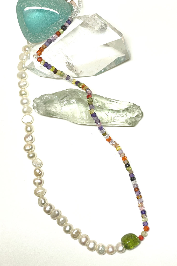 A chic and cool summer necklace made with creamy white pearls on one side and tiny faceted stones on the other, with a Peridot centre piece.