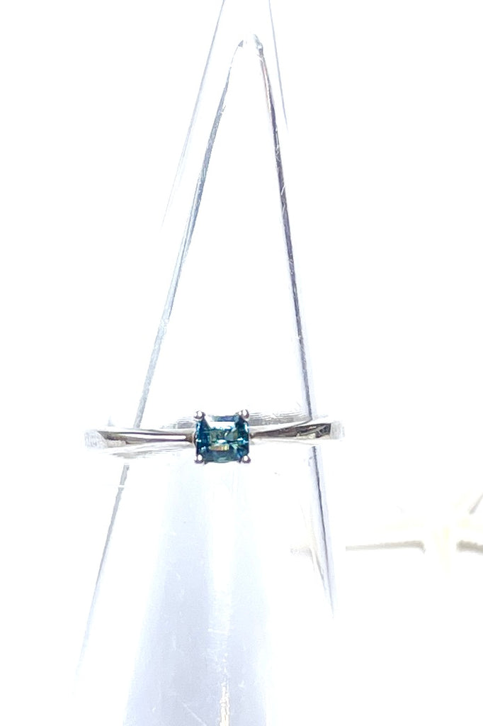 This pretty bright blue natural tourmaline has been cut in a square faceted stone. Set in a slightly raised prong setting.