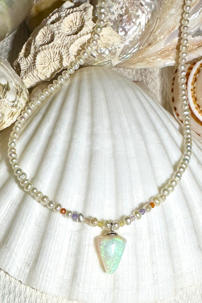 A pearl necklace with twist, we have added a tiny luminous crystal opal as the centrepiece.  Bright green, with misty blue and mauve all through the stone.