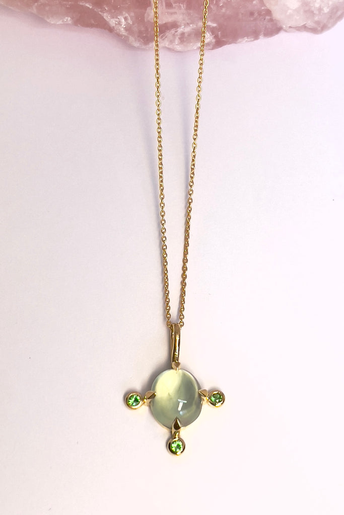 The pendant and chain are 9ct gold vermeil on a base of 925 silver, the gold is 2.5microns thick so will never rub or discolor An oval cabochon cut top quality Prehnite gemstone set in 9ct gold vermeil. Side stones are Sapphires.