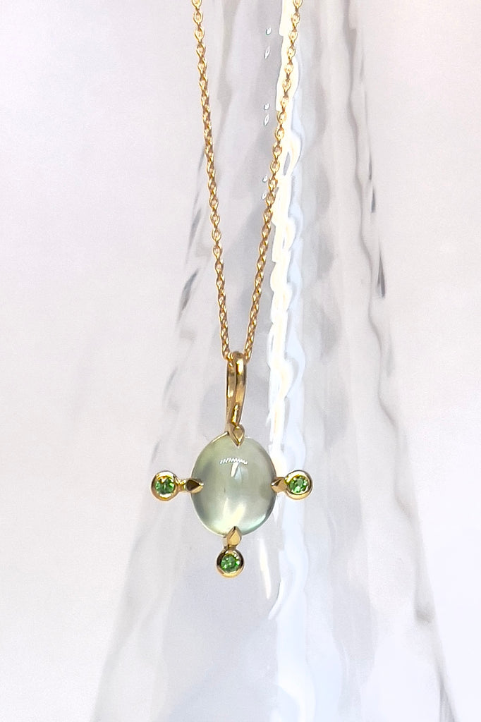 The pendant and chain are 9ct gold vermeil on a base of 925 silver, the gold is 2.5microns thick so will never rub or discolor An oval cabochon cut top quality Prehnite gemstone set in 9ct gold vermeil. Side stones are Sapphires.