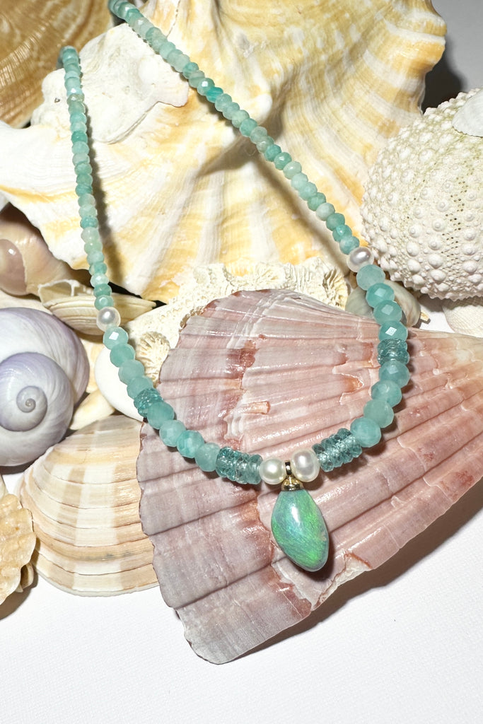 The prettiest splash of perfect wave blue, a splash of perfection, a swirl of green and teal on this tiny black opal pendant. Strung on little faceted Amazonite beads and a pretty pearls as a highlight.