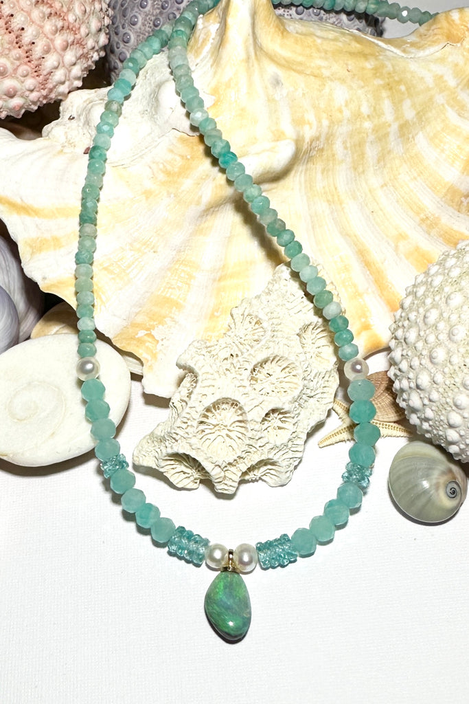 The prettiest splash of perfect wave blue, a splash of perfection, a swirl of green and teal on this tiny black opal pendant. Strung on little faceted Amazonite beads and a pretty pearls as a highlight.