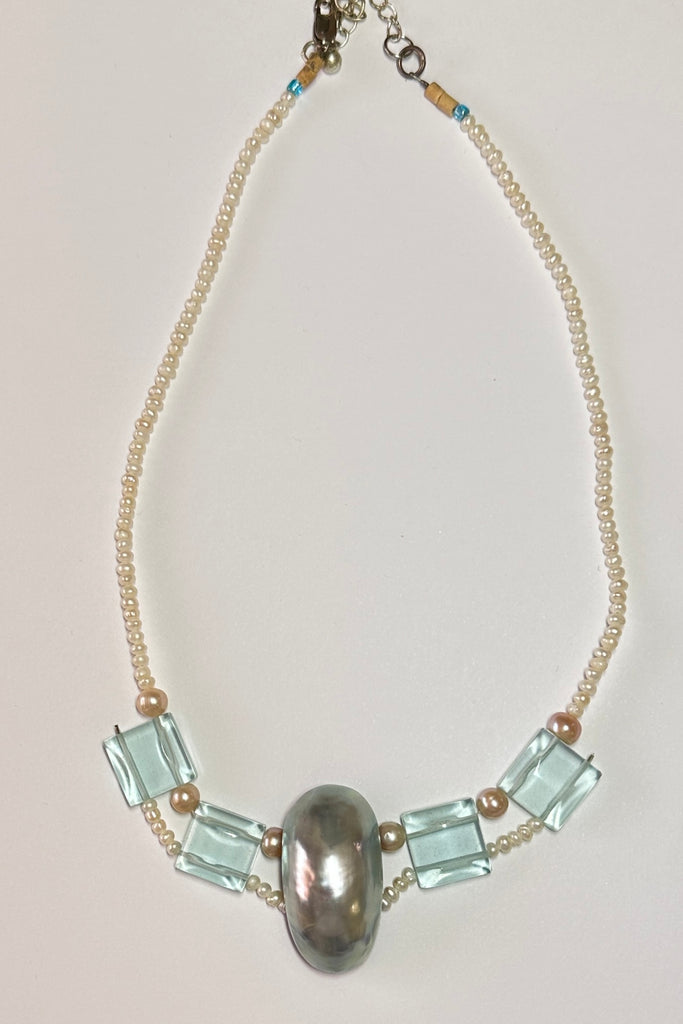 This pretty necklace is a one off piece made exclusively for Mombasa Rose Boutique. The centrepiece is a dome of silvery grey mother of pearl shell. The necklace is of cream natural pearls. 