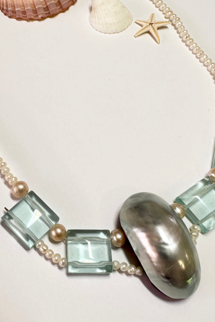 This pretty necklace is a one off piece made exclusively for Mombasa Rose Boutique. The centrepiece is a dome of silvery grey mother of pearl shell. The necklace is of cream natural pearls. 