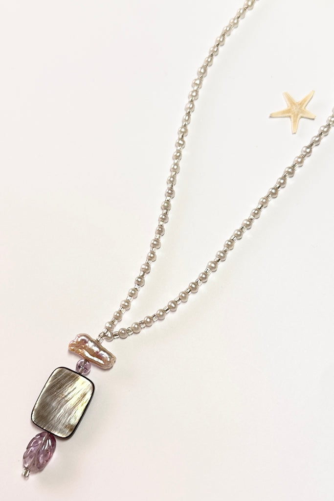This pretty necklace is a one off piece made exclusively for Mombasa Rose Boutique. The centrepiece is of silvery grey mother of pearl shell with a carved Amethyst leaf below.  The necklace is of cream natural pearls.