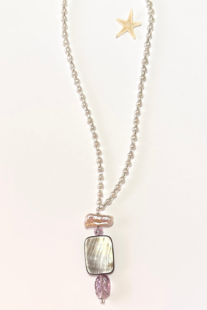 This pretty necklace is a one off piece made exclusively for Mombasa Rose Boutique. The centrepiece is of silvery grey mother of pearl shell with a carved Amethyst leaf below.  The necklace is of cream natural pearls.