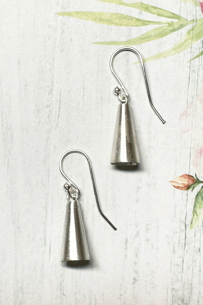 These tiny earrings are in a cone shape and look like a tiny bell. They have a lovely soft satin finish, and are light and comfortable to wear. Exclusive to Mombasa Rose Boutique.