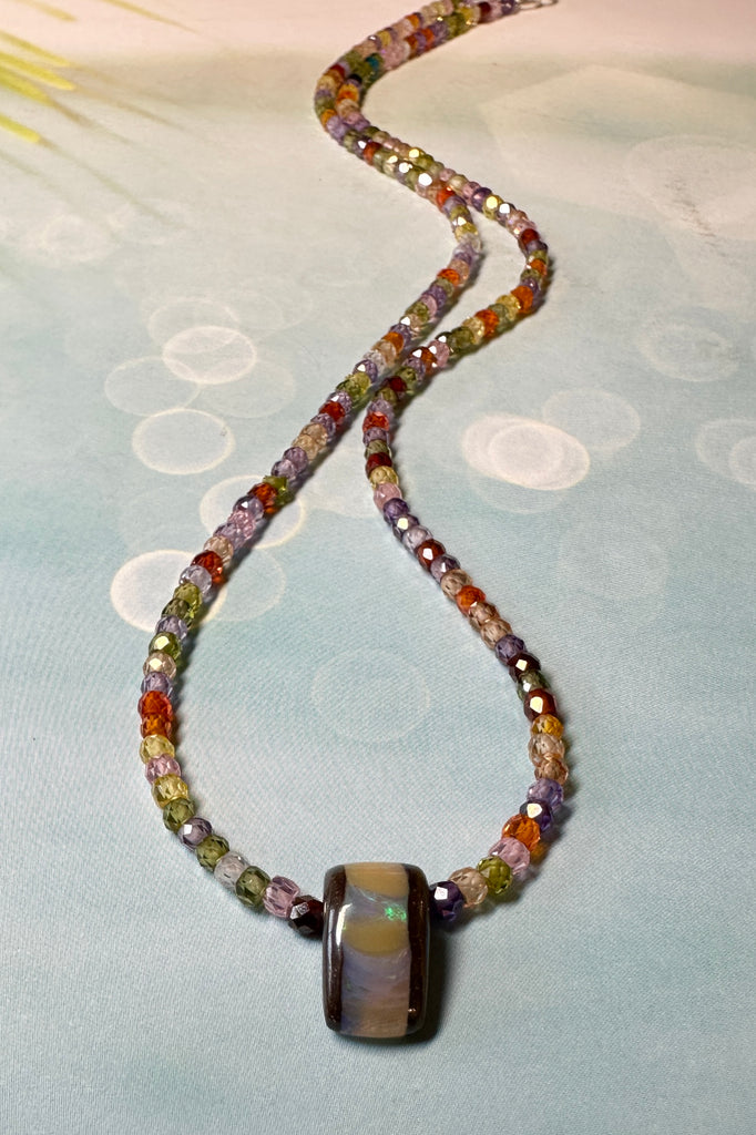 The Australian boulder opal pendant necklace is strung with very tiny faceted gemstones.