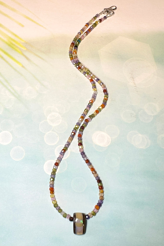The Australian boulder opal pendant necklace is strung with very tiny faceted gemstones.