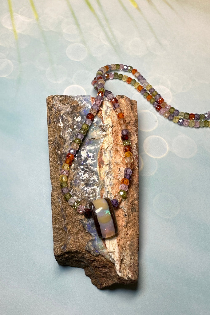The Australian boulder opal pendant necklace is strung with very tiny faceted gemstones.