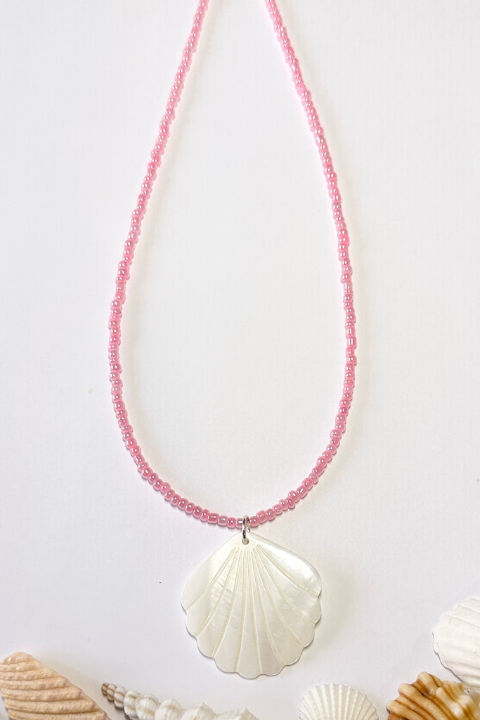 this scallop shape hand carved from Mother of Pearl shell all carry the distinctive marks of the artist who created them, no two shells are ever alike,  strung on pearlescent pale pink glass beads.