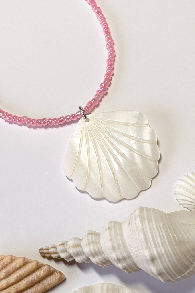 this scallop shape hand carved from Mother of Pearl shell all carry the distinctive marks of the artist who created them, no two shells are ever alike,  strung on pearlescent pale pink glass beads.