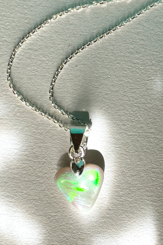 Natural solid Australian Crystal opal. One off piece. This tiny adorable little opal heart pendant has flash of bright green with some gold and blue as well. The surface has a beautiful polish. Comes on a 925 silver chain.