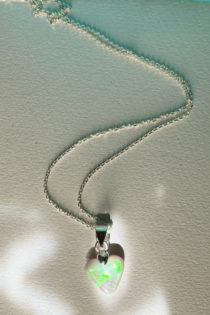 Natural solid Australian Crystal opal. One off piece. This tiny adorable little opal heart pendant has flash of bright green with some gold and blue as well. The surface has a beautiful polish. Comes on a 925 silver chain.