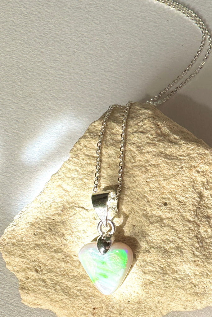 Natural solid Australian Crystal opal. One off piece. This tiny adorable little opal heart pendant has flash of bright green with some gold and blue as well. The surface has a beautiful polish. Comes on a 925 silver chain.