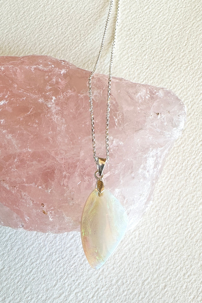 An opal pendant featuring a beautiful delicate whisper of Australian crystal opal cut into a triangle shape and polished to reveal the flecks of colour through the stone. A one of a kind opal.