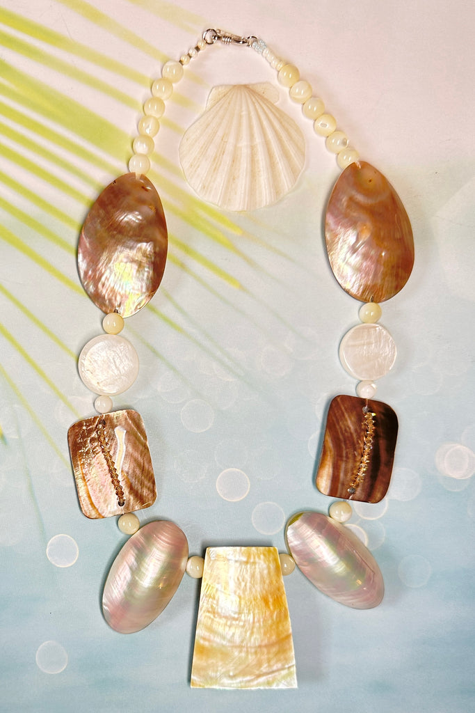 A necklace of differently shaped mother of pearl shells linked with crystals and shell beads beads. 