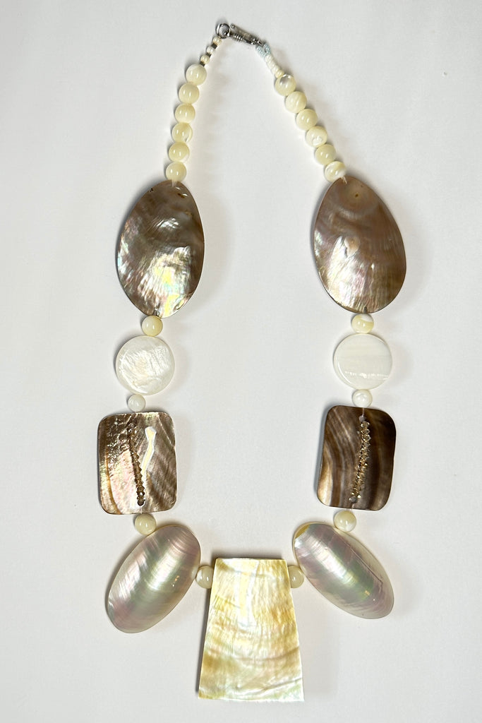 A necklace of differently shaped mother of pearl shells linked with crystals and shell beads beads. 