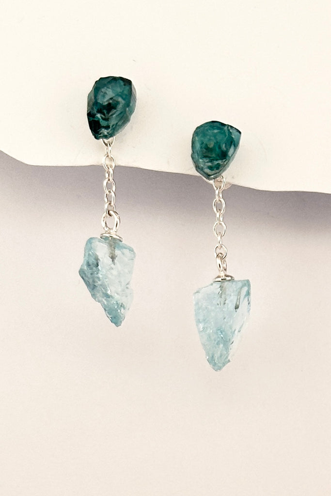 One off earrings made by hanging a natural crystal of natural Aquamarine off a tiny chain, the stud is a shard of teal green Tourmaline.