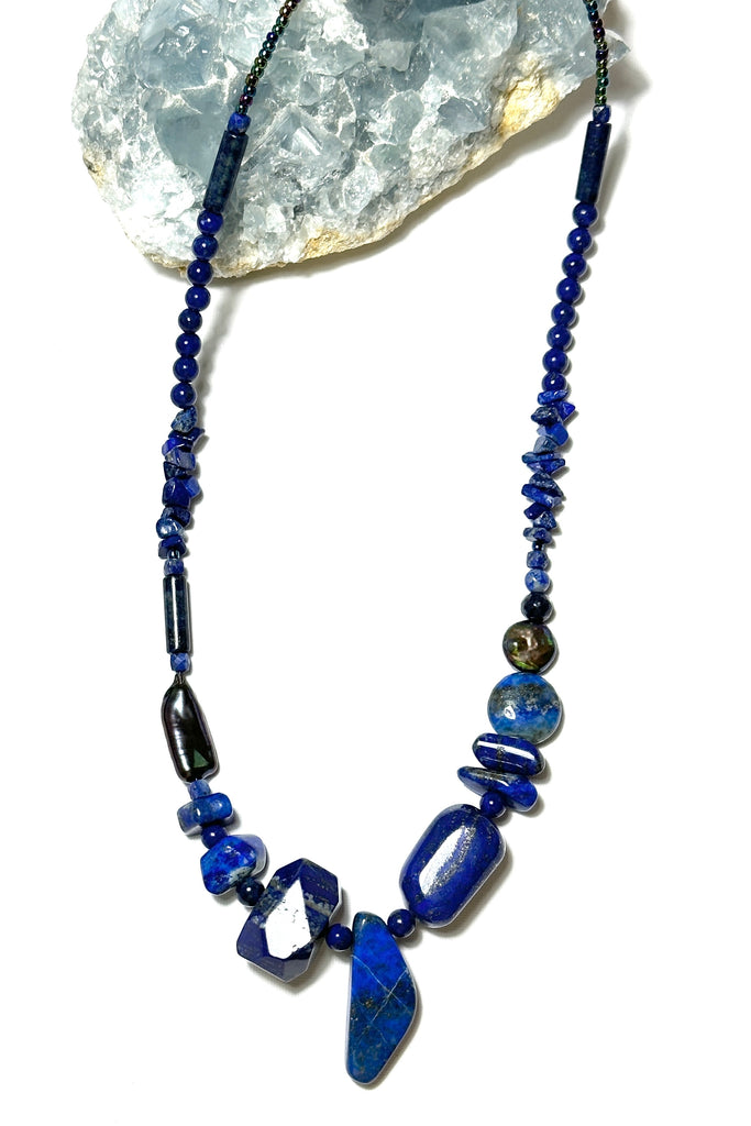 The necklace is made with different shapes of natural blue Lapis Lazuli beads with a highlight of two grey pearls