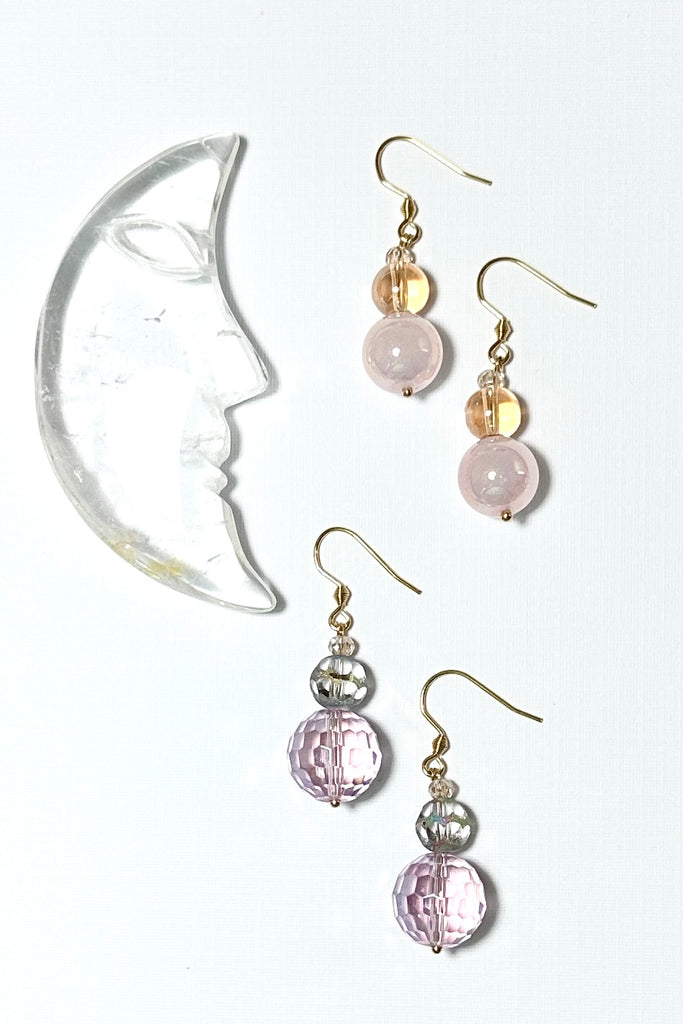 Chic earrings that are a dainty stack of sparkling crystal beads in pale pink and soft mauve, that swing from a goldtone hook. 