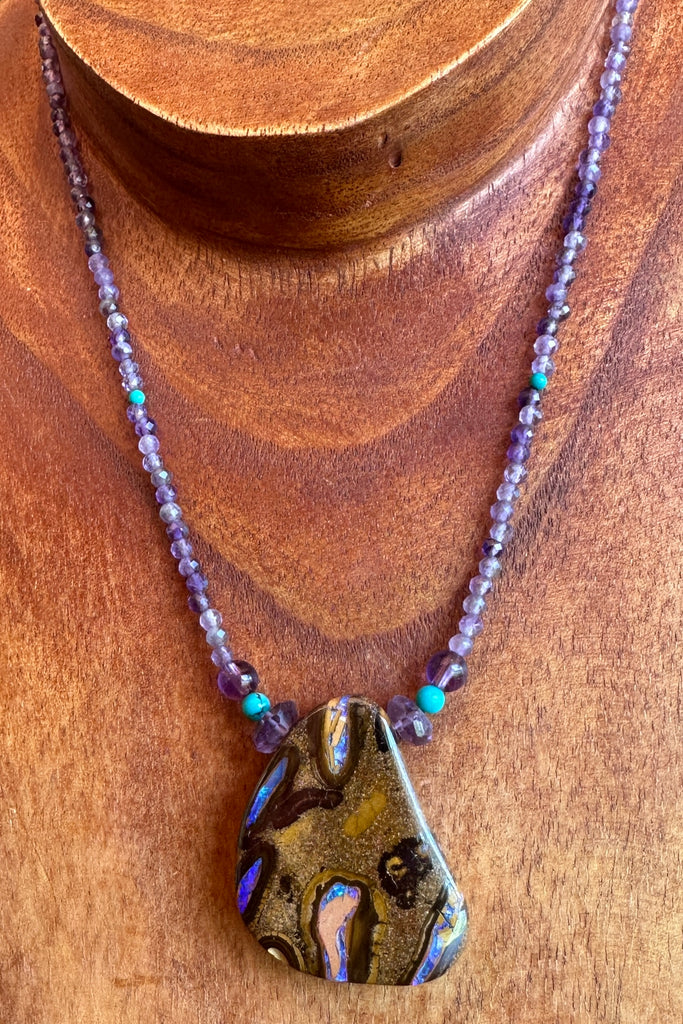 This necklace has been designed using a natural Australian Opal pendant strung on small faceted Amethyst beads enhanced with natural turquoise beads.