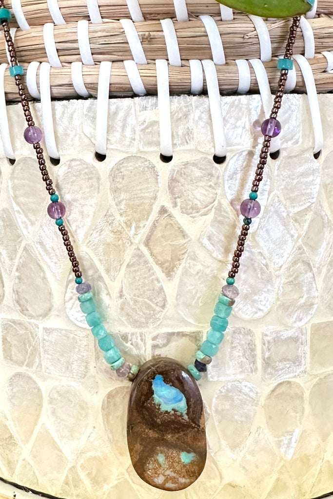 This necklace has been designed using a natural Australian Opal pendant strung on bronze coloured seed beads and enhanced with beads of Amazonite, Amethyst and natural Turquoise.