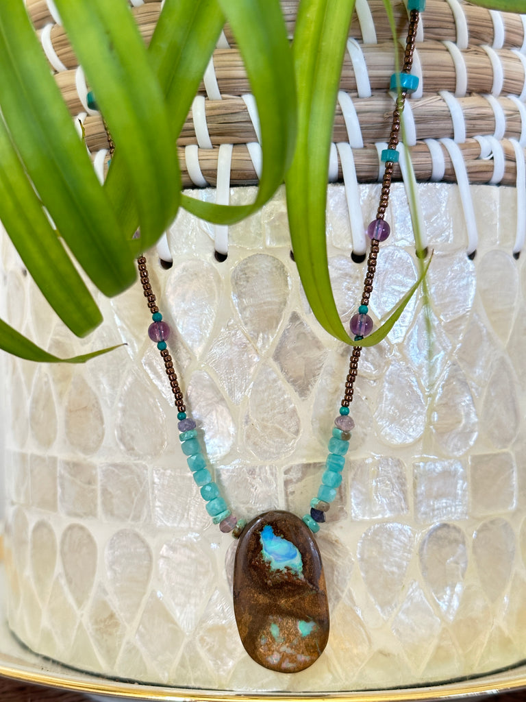 This necklace has been designed using a natural Australian Opal pendant strung on bronze coloured seed beads and enhanced with beads of Amazonite, Amethyst and natural Turquoise.