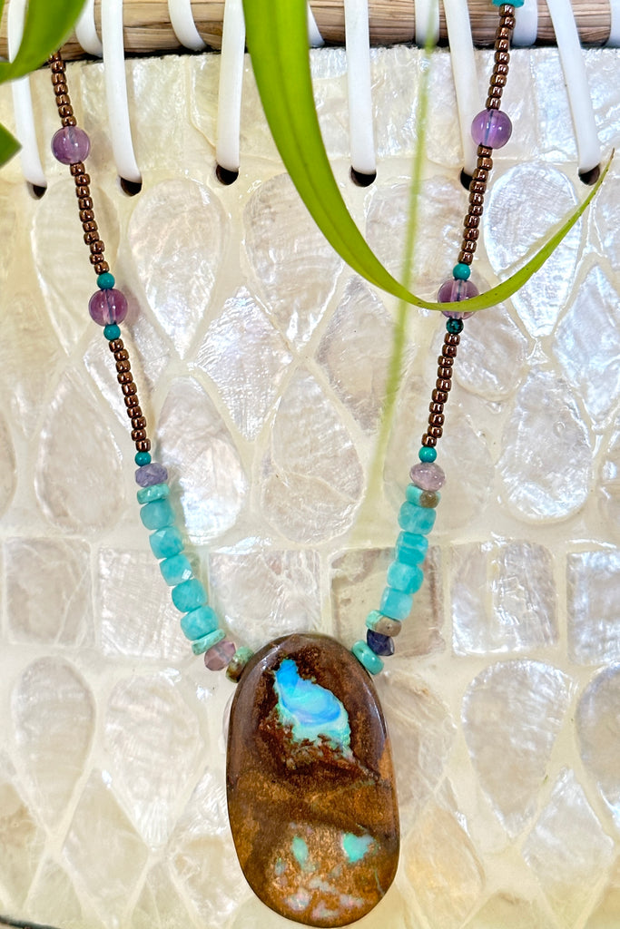 This necklace has been designed using a natural Australian Opal pendant strung on bronze coloured seed beads and enhanced with beads of Amazonite, Amethyst and natural Turquoise.