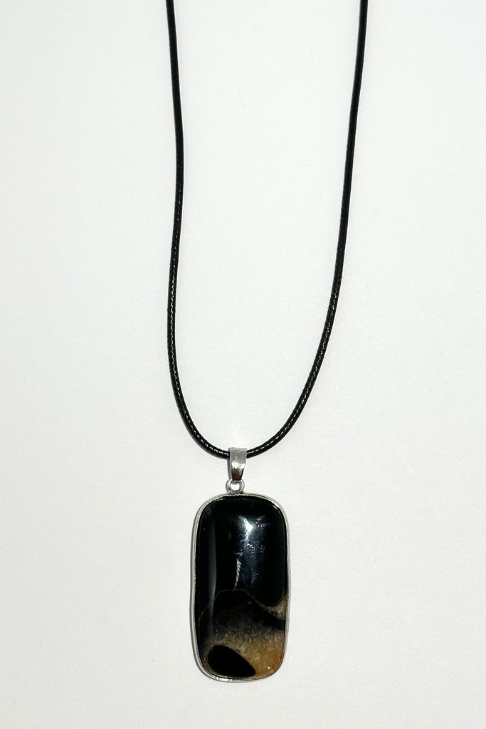 This unique pendant piece is cut from a solid black stone with gorgeous pale peach druzy inclusions at the base, different patterning on both sides.
