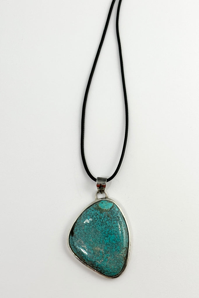 This vintage natural Turquoise pendant has the honest look of a preloved piece. It comes on a black cord necklace. This is a one off piece, handmade and showing the mark of the artist who designed it.