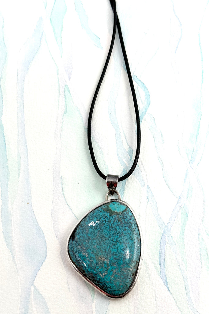 This vintage natural Turquoise pendant has the honest look of a preloved piece. It comes on a black cord necklace. This is a one off piece, handmade and showing the mark of the artist who designed it.
