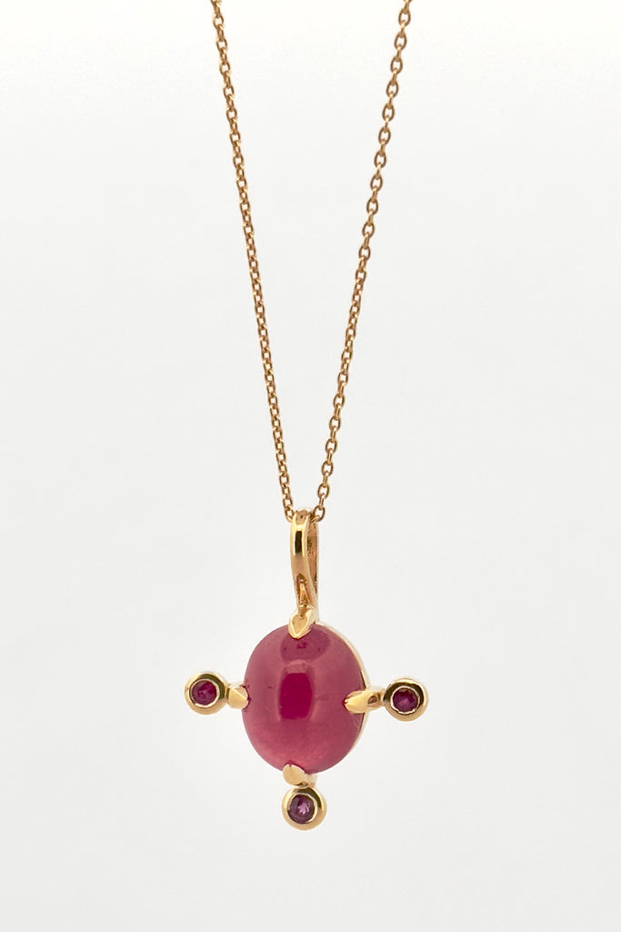 The pendant and chain are 9ct gold vermeil on a base of 925 silver, the gold is 2.5microns thick so will never rub or discolor An oval cabochon Ruby gemstone set in 9ct gold vermeil. Side stones are Sapphires. This pendant is a perfect celebration of femininity and chic. Pendant is 2.5cm long. Chain is gold vermeil