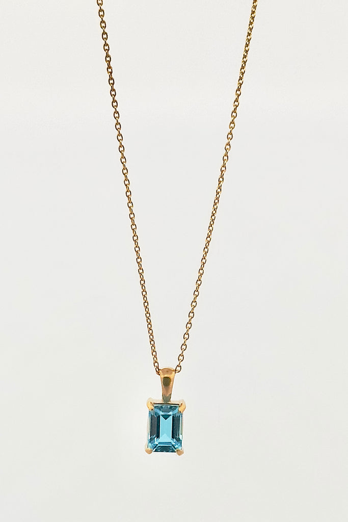 The pendant and chain are 9ct gold vermeil on a base of 925 silver, the gold is 2.5microns thick so will never rub or discolor An emerald cut Blue Topaz gemstone set in 9ct gold vermeil. Swiss blue Topaz gemstone. Pendant is 4cm long. Chain is gold vermeil