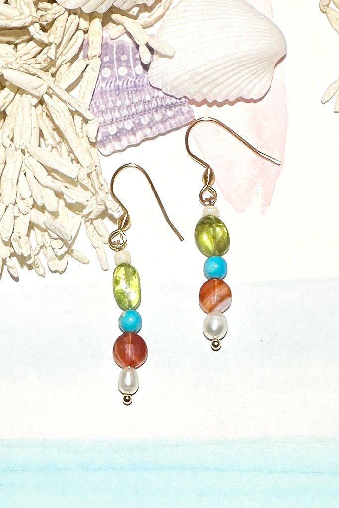 Our Inez gemstone earrings bring together an unusual colour combination, a perfect little swing style to add a pop of colour.

Turquoise Howlite, Carnelian, Peridot as well as a tiny pearl.