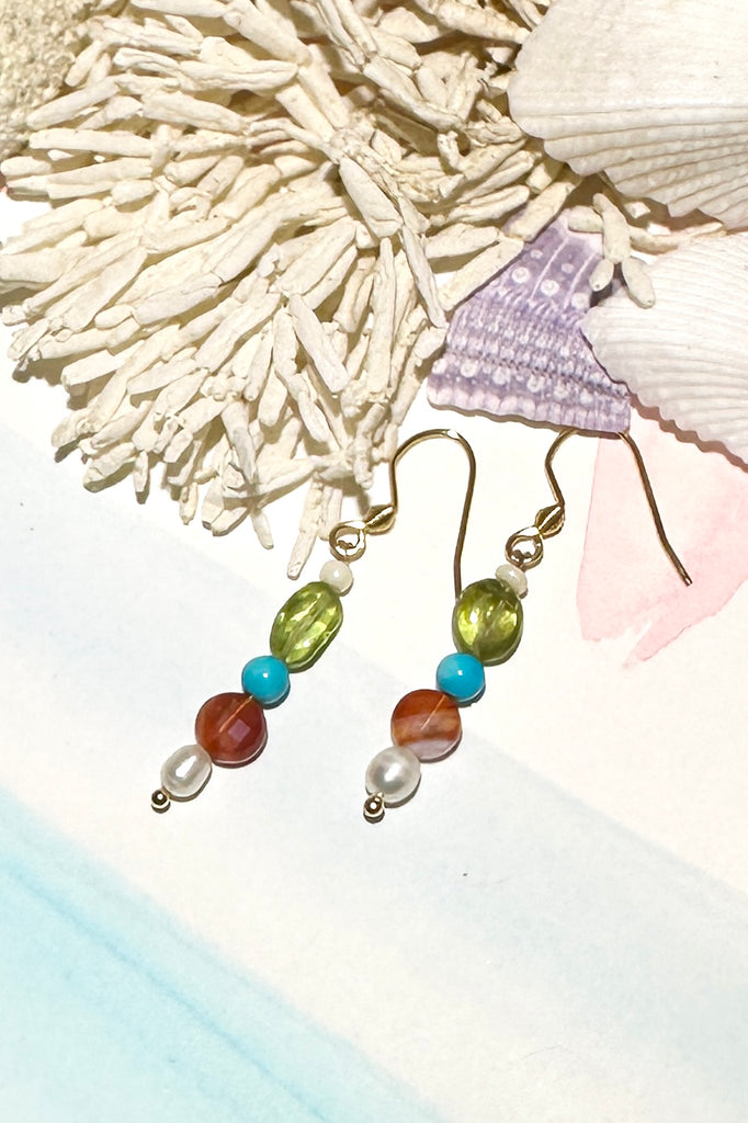 Our Inez gemstone earrings bring together an unusual colour combination, a perfect little swing style to add a pop of colour.

Turquoise Howlite, Carnelian, Peridot as well as a tiny pearl.